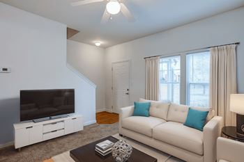 A living room with a white couch and a television.